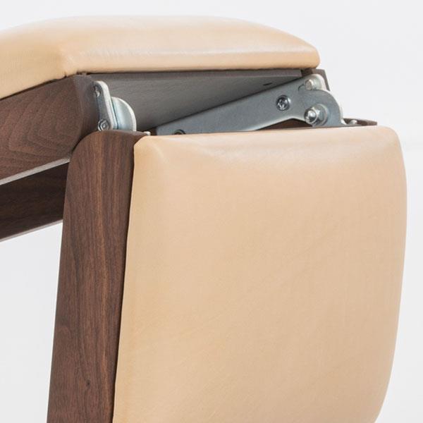 Detailansicht eines Fitnessgeräts mit Polsterung und Holzrahmen.