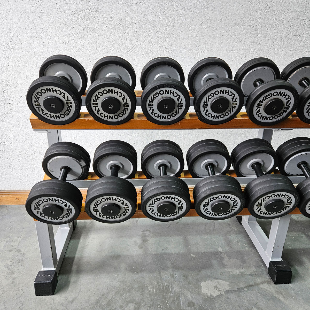 Technogym Kurzhantelsatz aus Guss mit Gummi Außenringen von 12 bis 40kg in 2kg Stufen ( 17 Paare ) + einige Paare doppelt Oldschool, Inkl. Kurzhantelablagen, gebraucht - mit Gebrauchsspuren