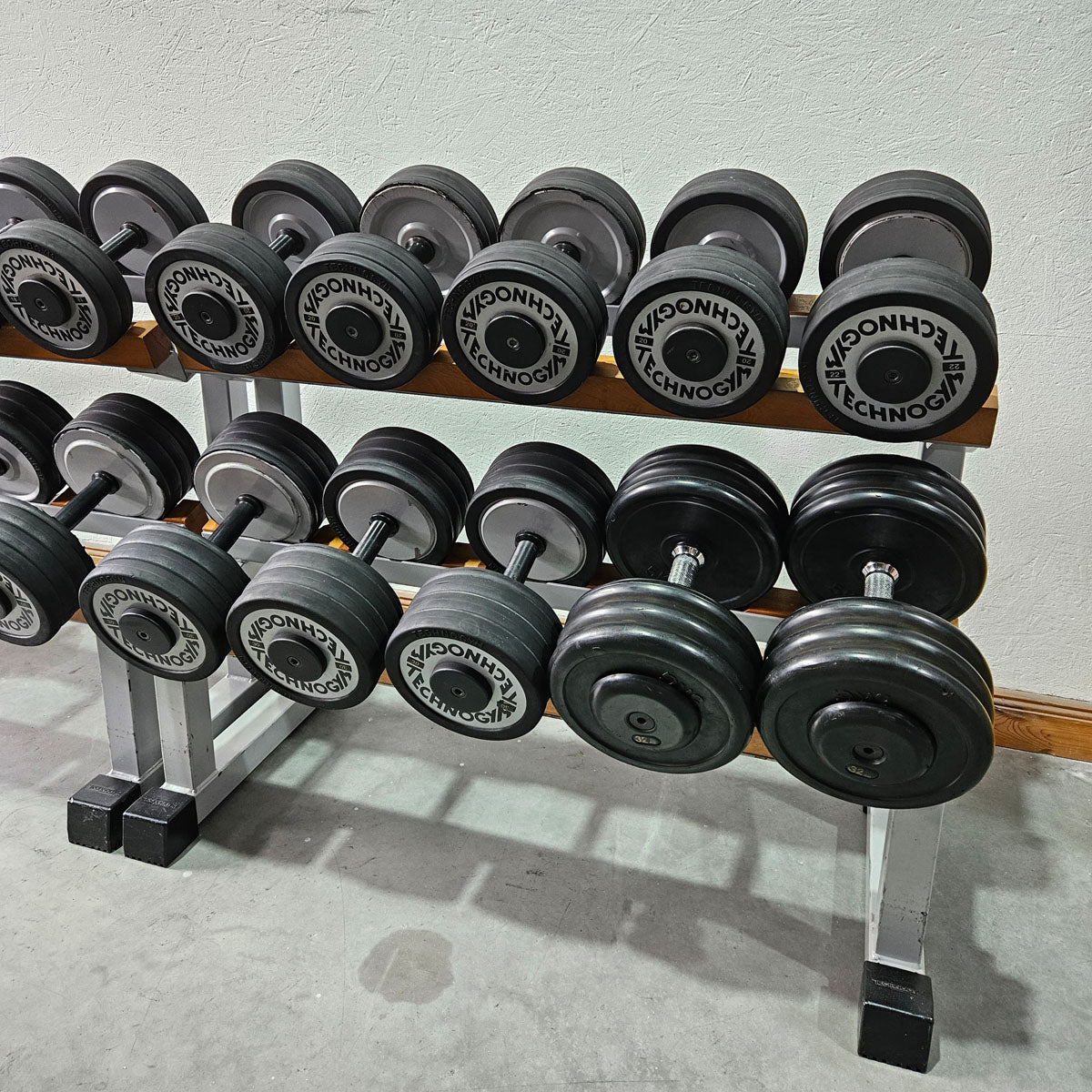 Technogym Kurzhantelsatz aus Guss mit Gummi Außenringen von 12 bis 40kg in 2kg Stufen ( 17 Paare ) + einige Paare doppelt Oldschool, Inkl. Kurzhantelablagen, gebraucht - mit Gebrauchsspuren