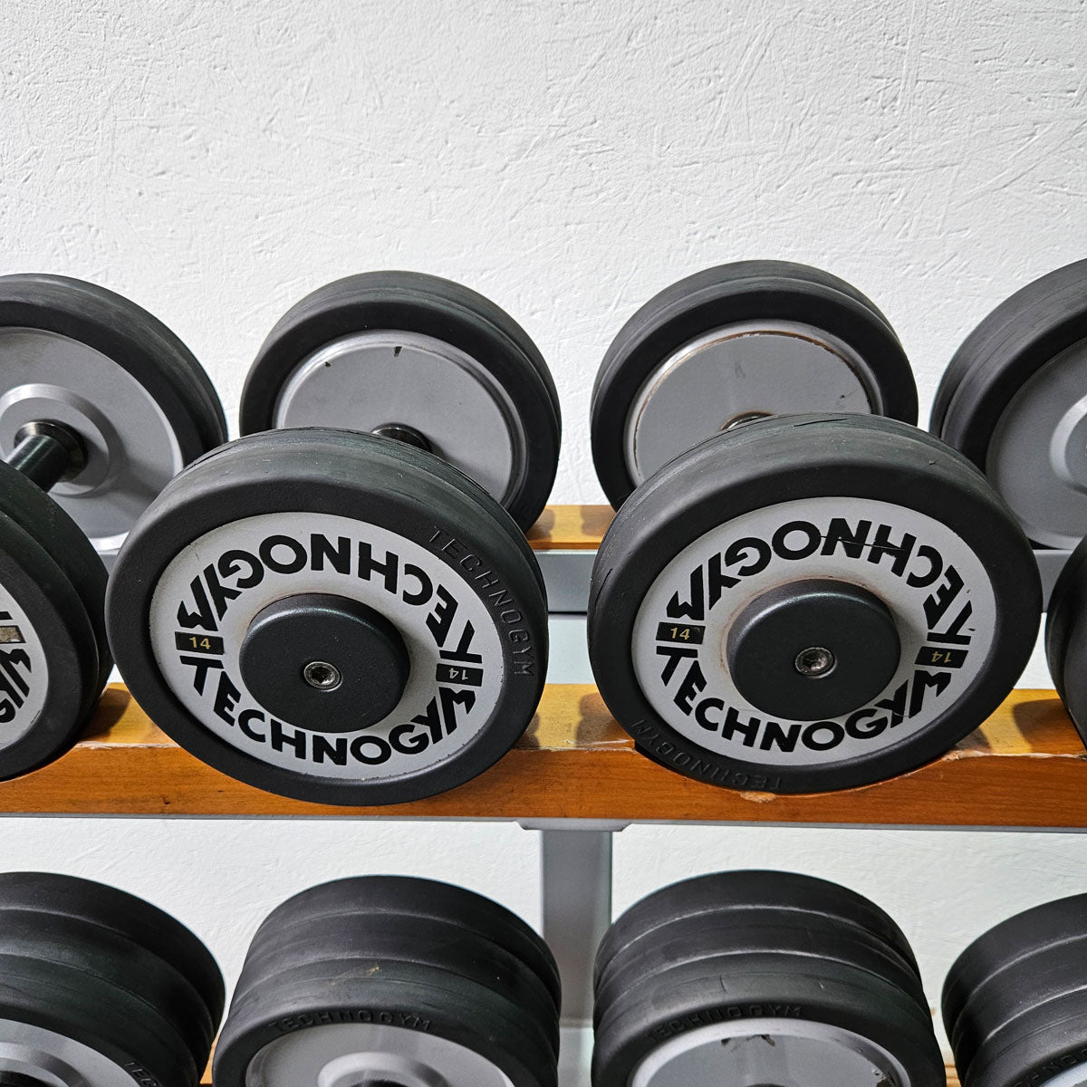 Technogym Kurzhantelsatz aus Guss mit Gummi Außenringen von 12 bis 40kg in 2kg Stufen ( 17 Paare ) + einige Paare doppelt Oldschool, Inkl. Kurzhantelablagen, gebraucht - mit Gebrauchsspuren