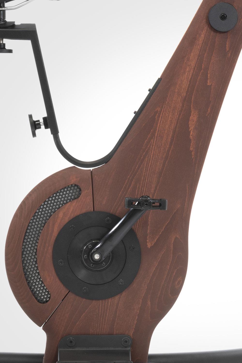 Holzseitenteil eines Fitnessgeräts mit Pedal und Mechanik.