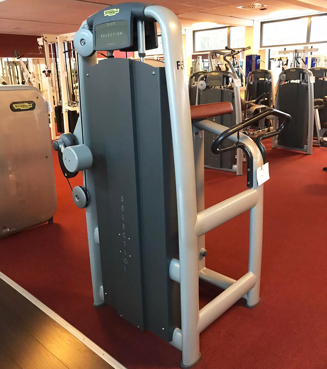 TechnoGym Gluteus Machine, Glute, Selection Line - New model with plastic cover, brown upholstery, used - refurbished condition