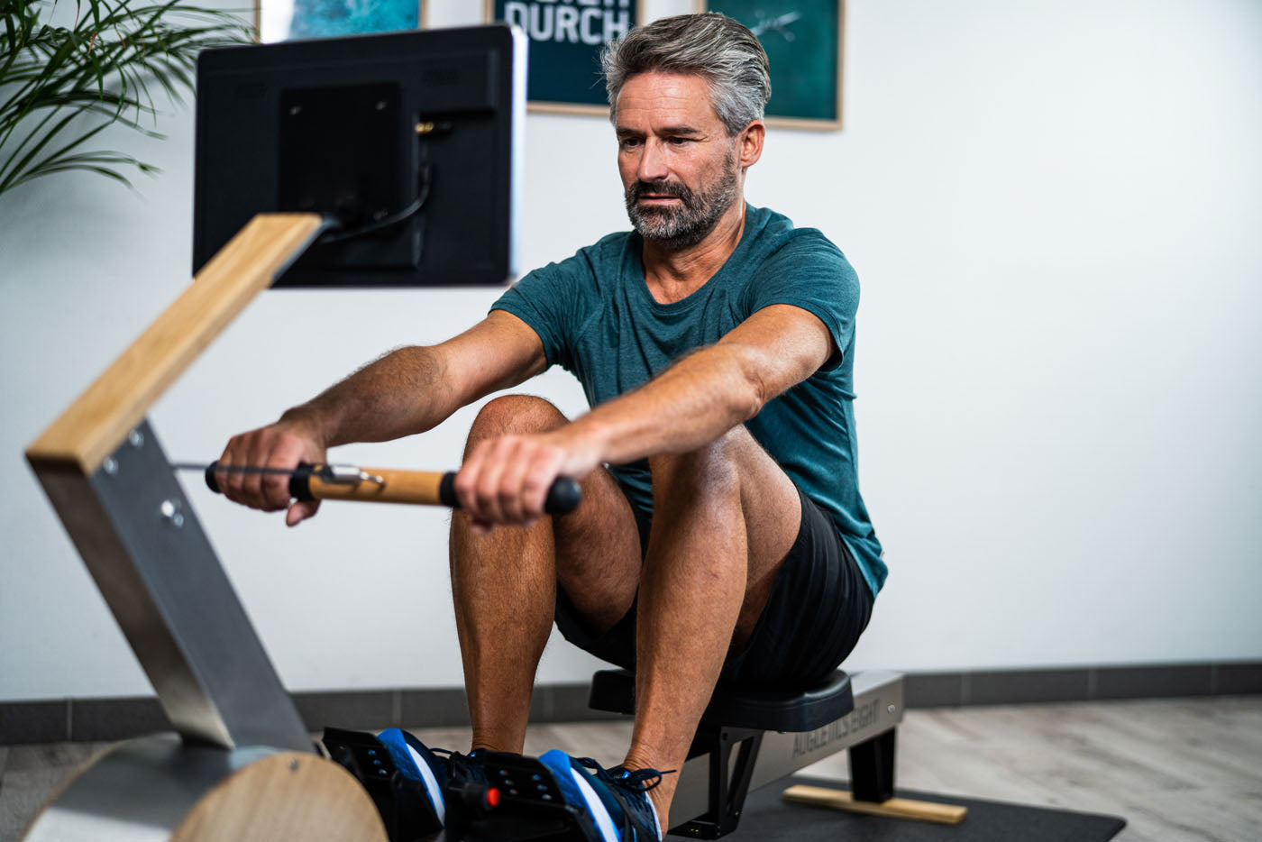 Person trainiert auf Rudergerät mit Bildschirm, Marke WaterRower.