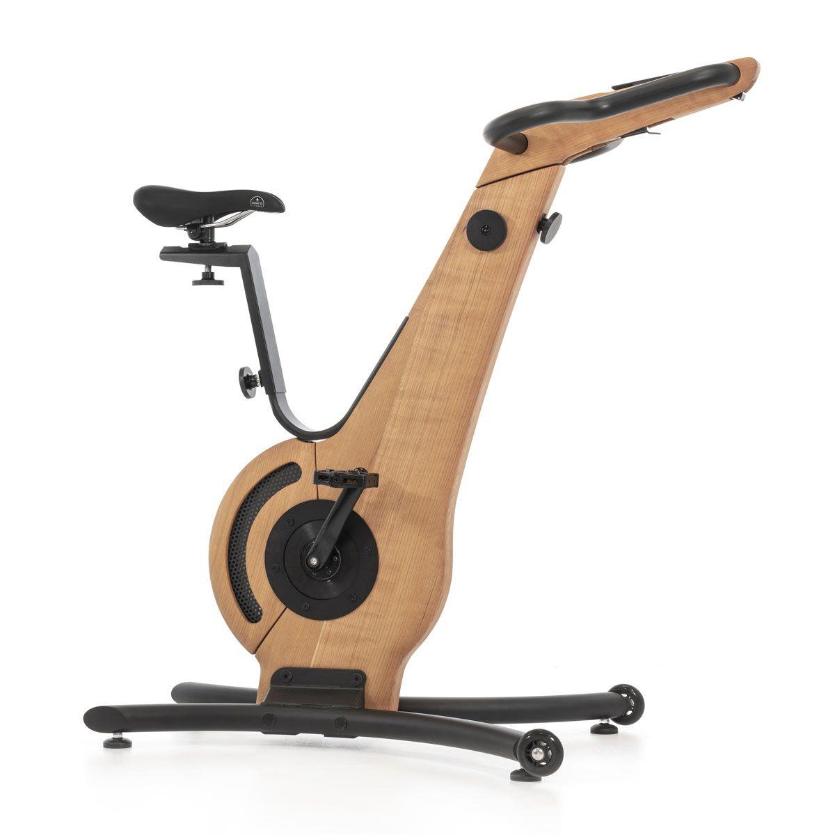 Holz-Design Heimtrainer mit Sattel und Pedalen, seitliche Ansicht.