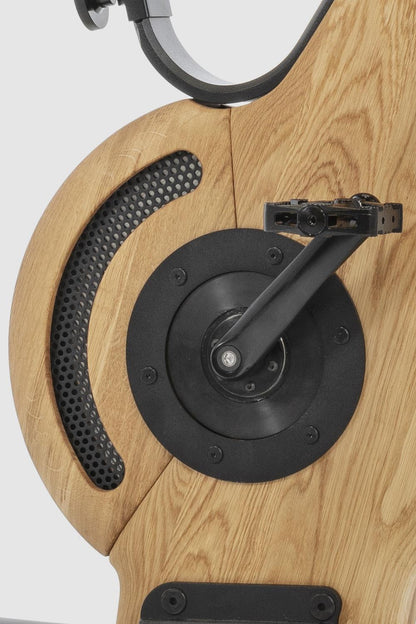 Holzseitenteil eines Fitnessgeräts mit Pedal und Metallgitter.