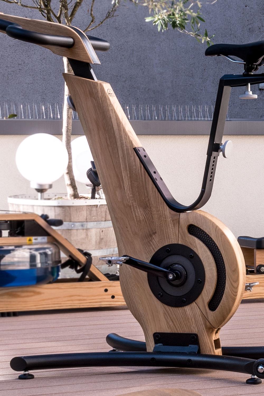 Holzspinningrad auf Terrasse, Markenname WaterRower sichtbar.
