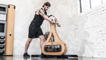 Person trainiert mit WaterRower Fitnessgerät in hellem Raum.