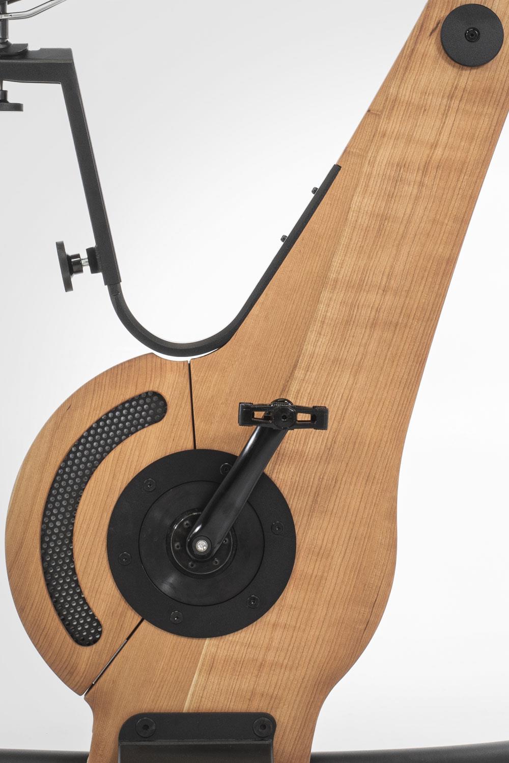 Holz-Fitnessgerät mit Pedal und schwarzem Metallrahmen.